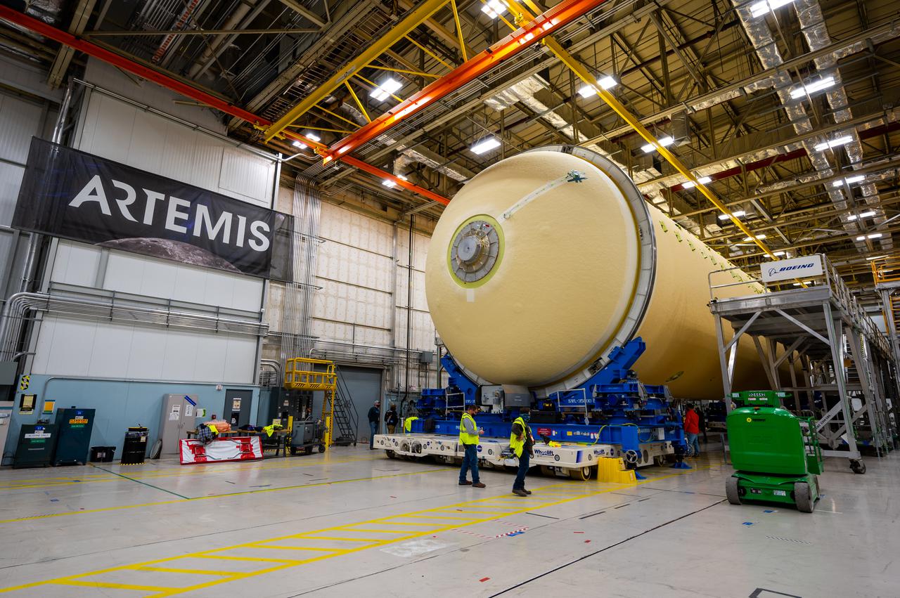 Technicians transported the assembled upper part of the Artemis II core stage to the final assembly area inside the factory at NASA’s Michoud Assembly Facility in New Orleans. On Jan 10, the forward assembly, left was moved next to the Artemis II liquid hydrogen tank, which has been undergoing assembly. Next, Boeing, the lead core stage contractor, will join the forward assembly and the liquid hydrogen tank to complete most of the core stage for the Space Launch System (SLS) rocket that will send the first crew on an Artemis mission. The core stage consists of five major structures that are built, outfitted, and then connected to form the final stage. The forward skirt, liquid oxygen and intertank were connected and tested to form the 66-foot forward assembly. After the forward assembly is joined with the 130-foot liquid hydrogen tank, only the engine section, the fifth piece of the stage, will need to be added to complete the Artemis II core stage. The core stage serves as the backbone of the rocket, supporting the weight of the payload, upper stage, and crew vehicle, as well as the thrust of its four RS-25 engines and two five-segment solid rocket boosters attached to the engine and intertank sections. On Artemis II, the SLS rocket will launch the Orion spacecraft and a crew, sending them into lunar orbit, in preparation for later Artemis missions that will enable the first woman and first person of color to land on the Moon.
